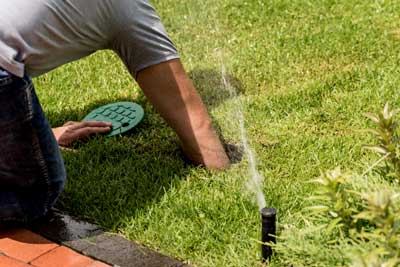 photo of person turning off sprinklers